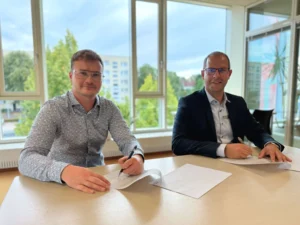 Lucas Rehfeld und Bürgermeister Philipp Stark unterzeichnen Kooperationsvertrag am Tisch in hellem Büro